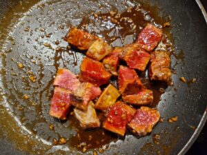Steakwürfel in Sake Honig Sauce schwenken